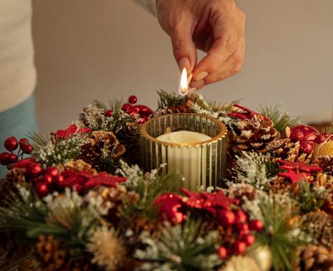 woman-lighting-wreath-candle-fire-1